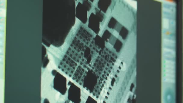 Un technicien de laboratoire examine une image radiographique d'un microcircuit sur un écran d'ordinateur .