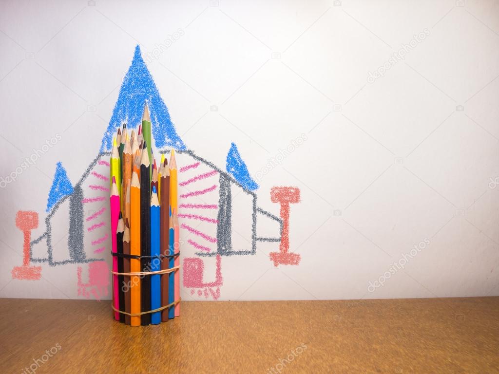Coloring pencils tied together on the desk with paintings rockets.