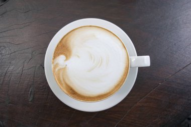 Beyaz fincan kahve, latte ahşap masa üzerinde kapatın