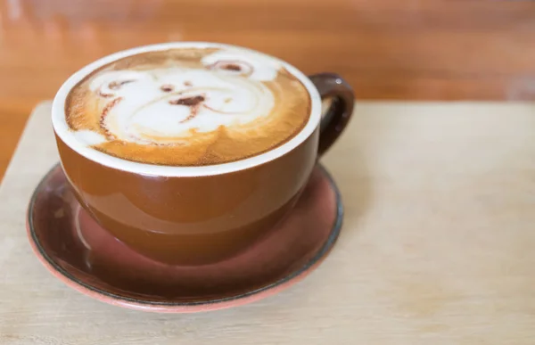 Tutup cangkir kopi putih dengan tangan beruang yang digambar di atas, kopi latte di atas kayu . — Stok Foto