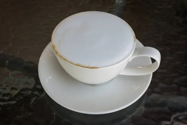 Close up white cup of Coffee, latte with beautiful milk foam on the glass table. — Stock Photo, Image