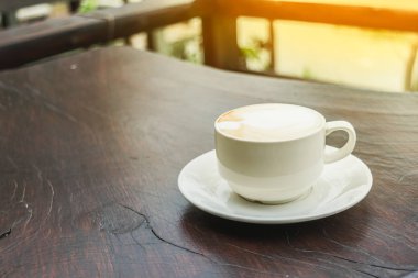 Beyaz fincan kahve, latte güzel latte art ahşap masa tarih ile kapatmak.