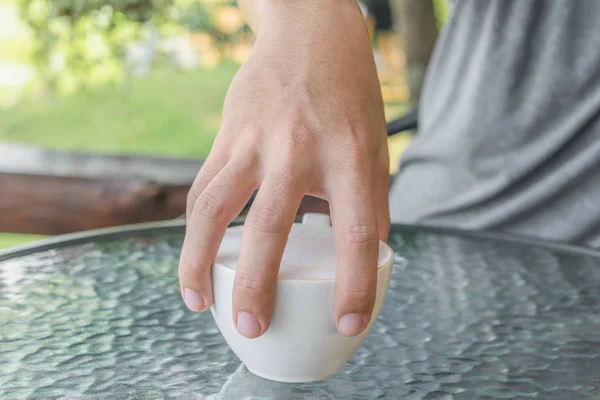 Selectieve aandacht bij de hand is man met koffiemok met een heleboel melk schuim. Liefdevolle koffie concept. — Stockfoto