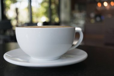 Seçici odak beyaz fincan kahve, latte ahşap tablo.