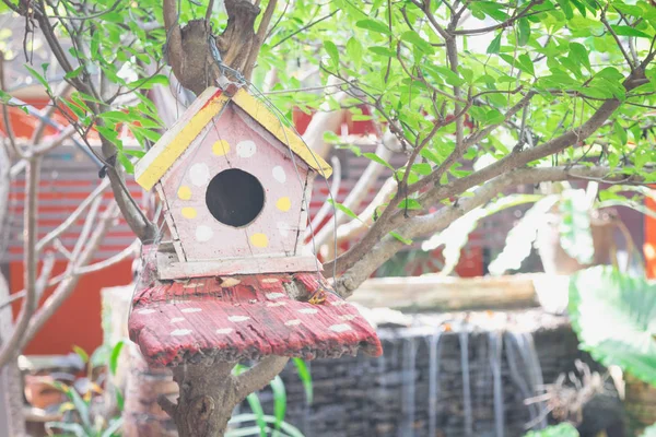 Casa de passarinho rosa abaixo de uma árvore em um dia ensolarado. Conceito de paz e relaxamento . — Fotografia de Stock