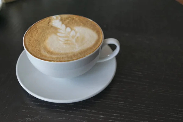 Taza de café en la mesa de madera en la cafetería. —  Fotos de Stock