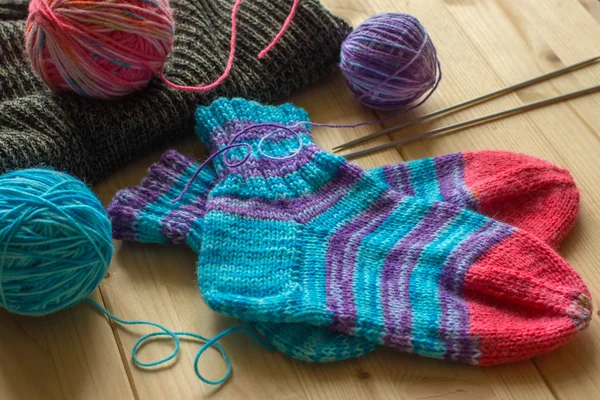 Handmade knitted baby socks, multicolor wool skeins — Stock Photo, Image