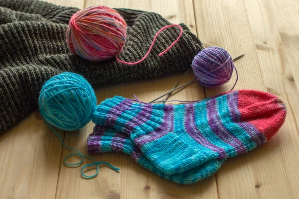 Knitted baby socks handmade, skeins of wool — Stock Photo, Image
