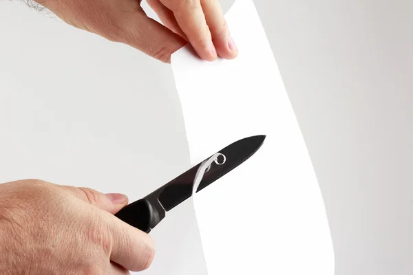Penge éles késsel vágjuk át a fehér könyv — Stock Fotó