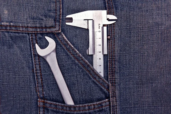 Chave de ferramentas e micrômetro no bolso jeans — Fotografia de Stock