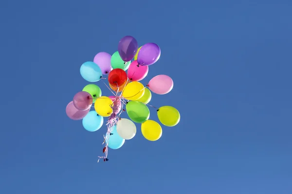 Bunte Ballons fliegen in den blauen Himmel — Stockfoto