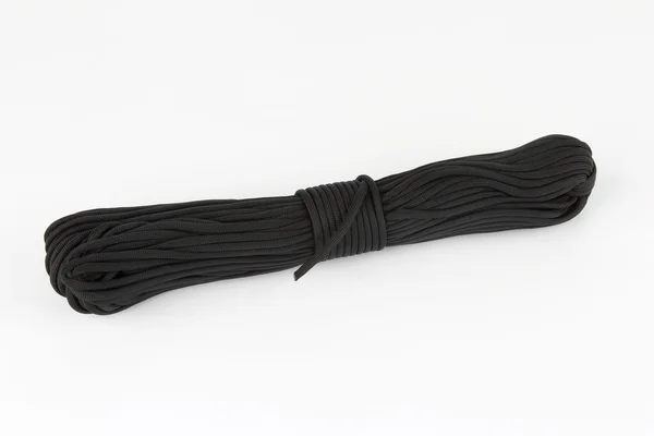 Bobina de cuerda oscura paracord sobre un fondo blanco —  Fotos de Stock
