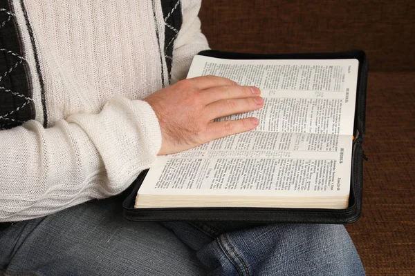 男人的牛仔裤和白色衬衫读取俄罗斯的圣经 — 图库照片
