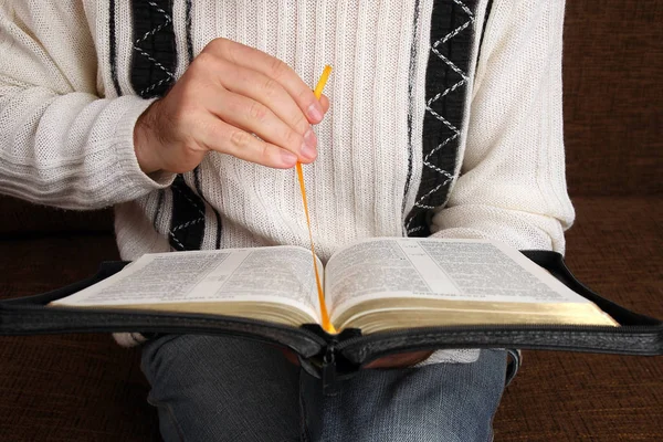 Hombre se sienta con un primer plano abierto de la Biblia — Foto de Stock