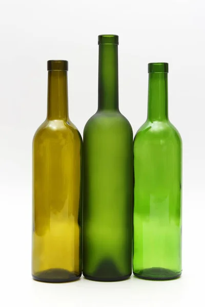 Três garrafas vazias de vinho no fundo branco — Fotografia de Stock