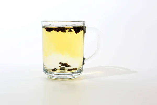 Taza de té transparente con crema sobre fondo blanco — Foto de Stock