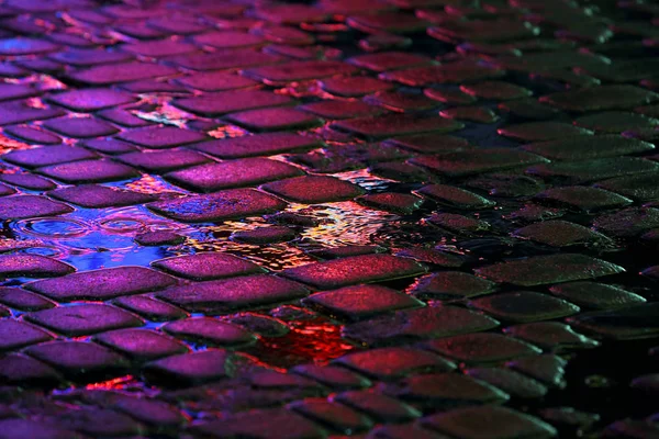 Reflection of the advertising lights on the stones of the road — Stock Photo, Image