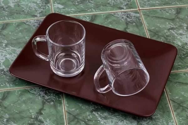 Két átlátszó csésze barna tányéron — Stock Fotó