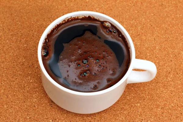 Taza blanca de café negro caliente en una mesa de corcho —  Fotos de Stock
