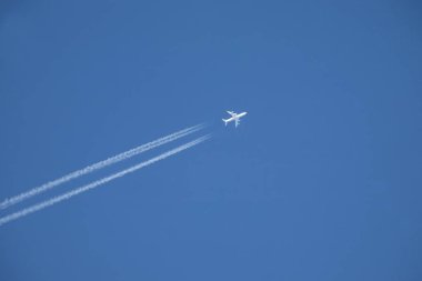 yüksek mavi gökyüzünde uçan beyaz jet uçak