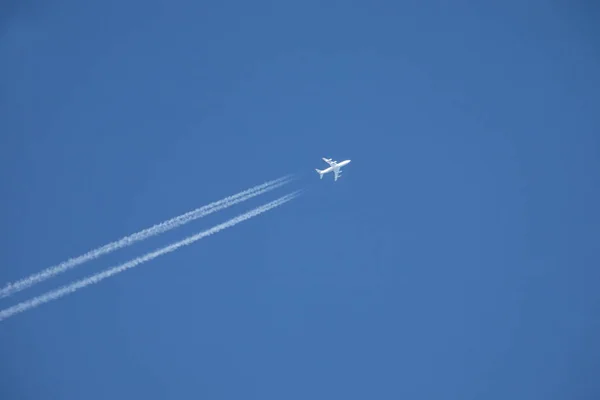Avião a jato branco voando alto no céu azul — Fotografia de Stock
