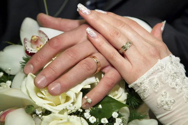 Mani degli sposi sul bouquet da sposa — Foto Stock