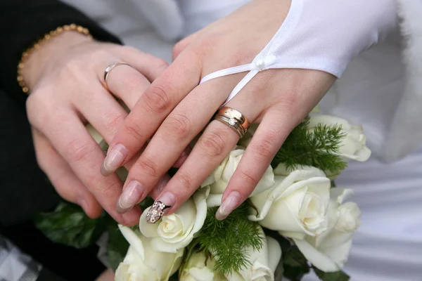 Τα χέρια της νύφης και του γαμπρού πάνω γαμήλια ανθοδέσμη — Φωτογραφία Αρχείου
