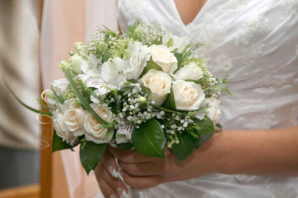 невеста держит свадебный букет крупным планом
