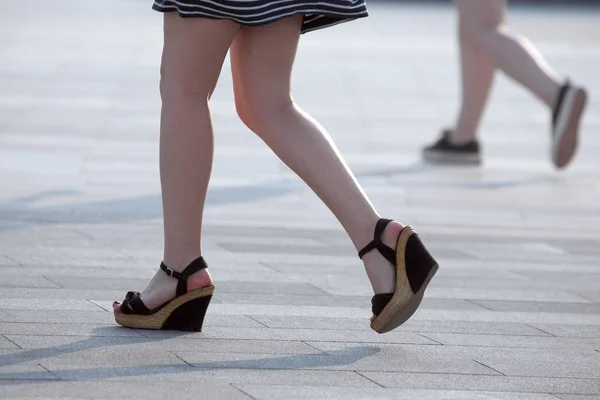 Chůzi nohy ženy na slunci podsvícení — Stock fotografie