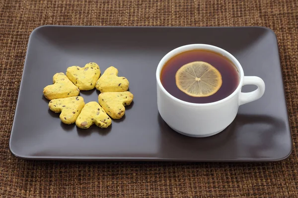White cup of tea with lemon and biscuits — Stock Photo, Image