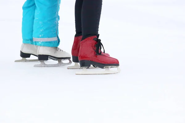Voet van twee meisjes schaatsen op de ijsbaan — Stockfoto