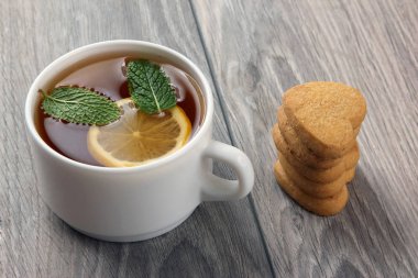 Beyaz fincan çay limon ve ahşap bir masa tanımlama bilgilerini