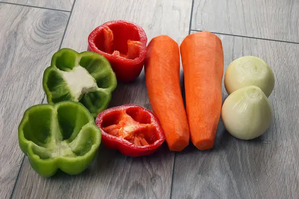 Oignon tranché et poivre sur une planche de cuisine avec des carottes — Photo