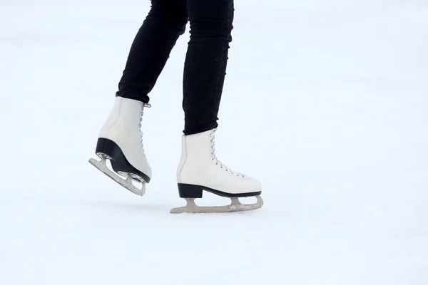 Die Beine eines Mannes, der auf Schlittschuhen auf der Eisbahn rollt — Stockfoto