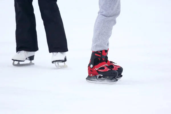 Die Beine eines Mannes, der auf einer Eisbahn Schlittschuh läuft — Stockfoto