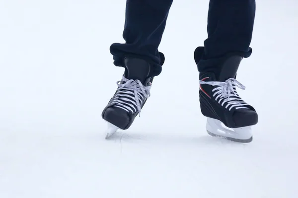 The legs of a man rolling on skates on the ice rink — Stock Photo, Image