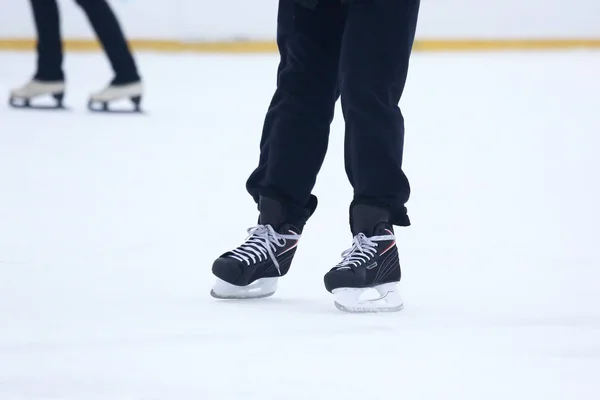 Die Beine eines Mannes, der auf einer Eisbahn Schlittschuh läuft — Stockfoto