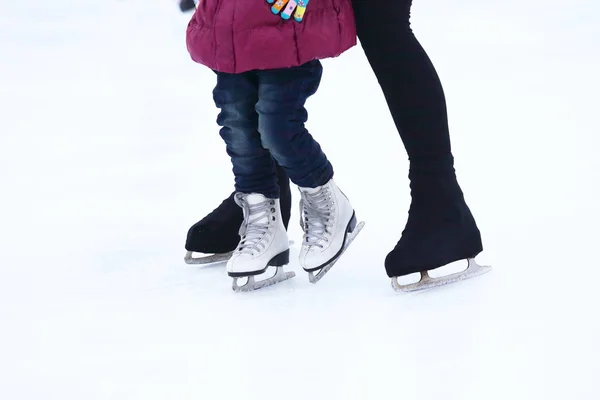 Das Kind und der Mann laufen auf der Eisbahn — Stockfoto