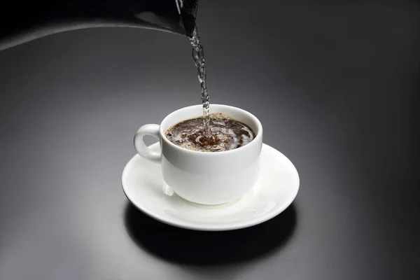 ブラック コーヒーと白いカップにお湯を注いだ — ストック写真