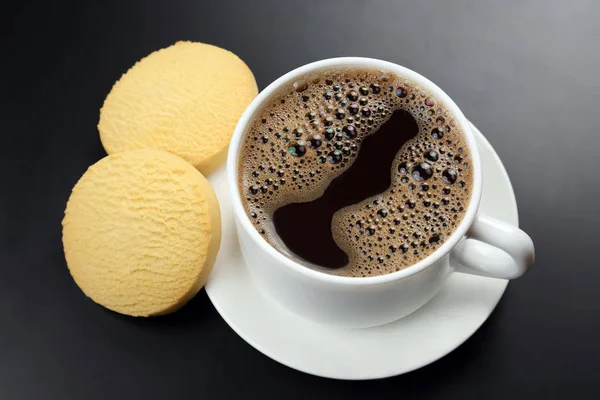 Taza blanca de café negro con galletas sobre un fondo oscuro —  Fotos de Stock