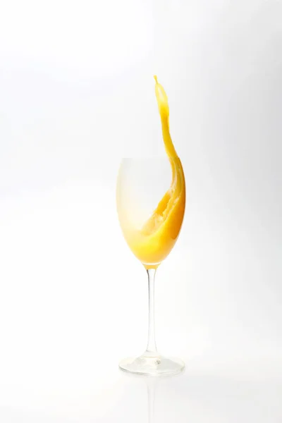 Respingo de suco de laranja no vidro no fundo branco — Fotografia de Stock