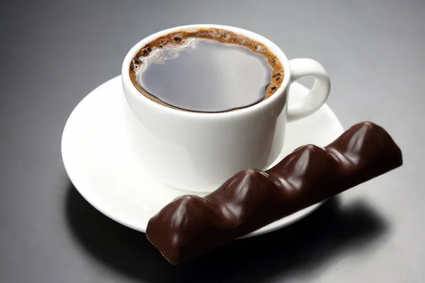 Taza blanca con café negro y chocolate en el platillo — Foto de Stock