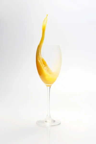 Spritzer Orangensaft im Glas auf weißem Hintergrund — Stockfoto