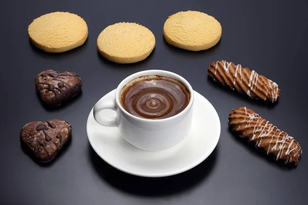 Белая чашка черного кофе с печеньем на темном фоне — стоковое фото
