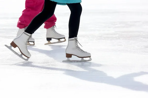 Patins para crianças e adultos na pista de gelo — Fotografia de Stock