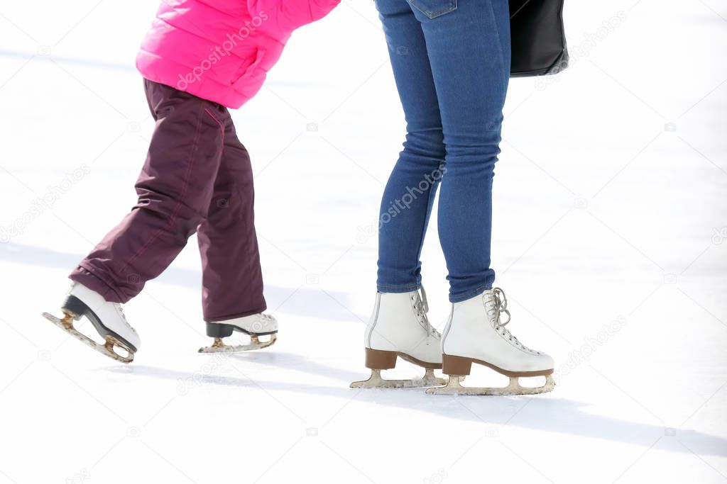 child and adult skates at the ice rink