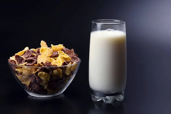 Copos de maíz en un plato y un vaso de leche —  Fotos de Stock