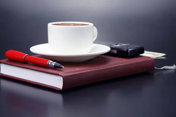 Червона ручка є тарілкою чашка чорної кави — стокове фото
