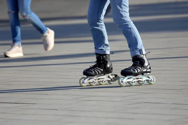 Jambes rouler sur des patins à roulettes en arrière-plan personne à pied — Photo