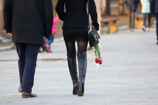 Mulher com flores tulipas na mão, andando ao lado do homem — Fotografia de Stock